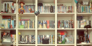 A shelf full of books, DVDs, games, and toys.